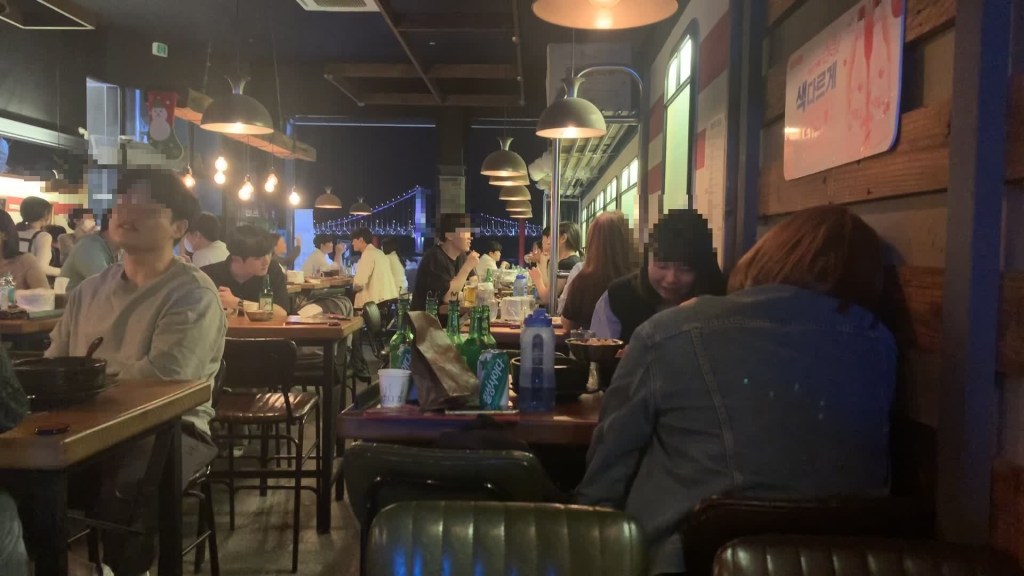 Busy evening restaurant near Gwangalli with Gwangan Bridge visible outside