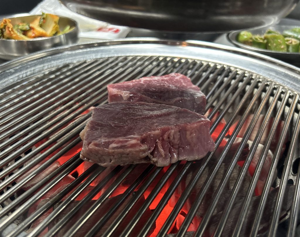 Hanwoo beef grilling over direct heat at a Korean barbecue restaurant