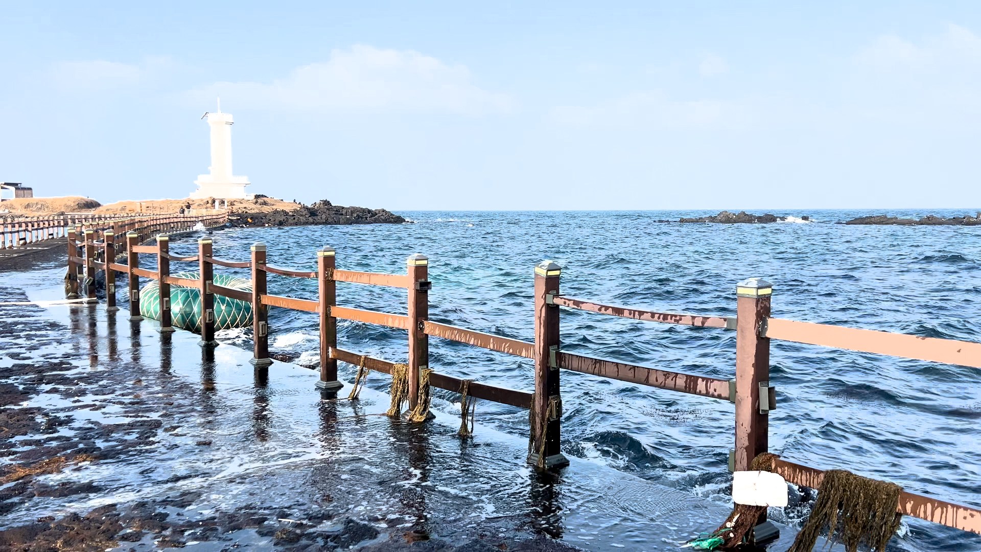 Jeju coastal road stop with waves and a lighthouse