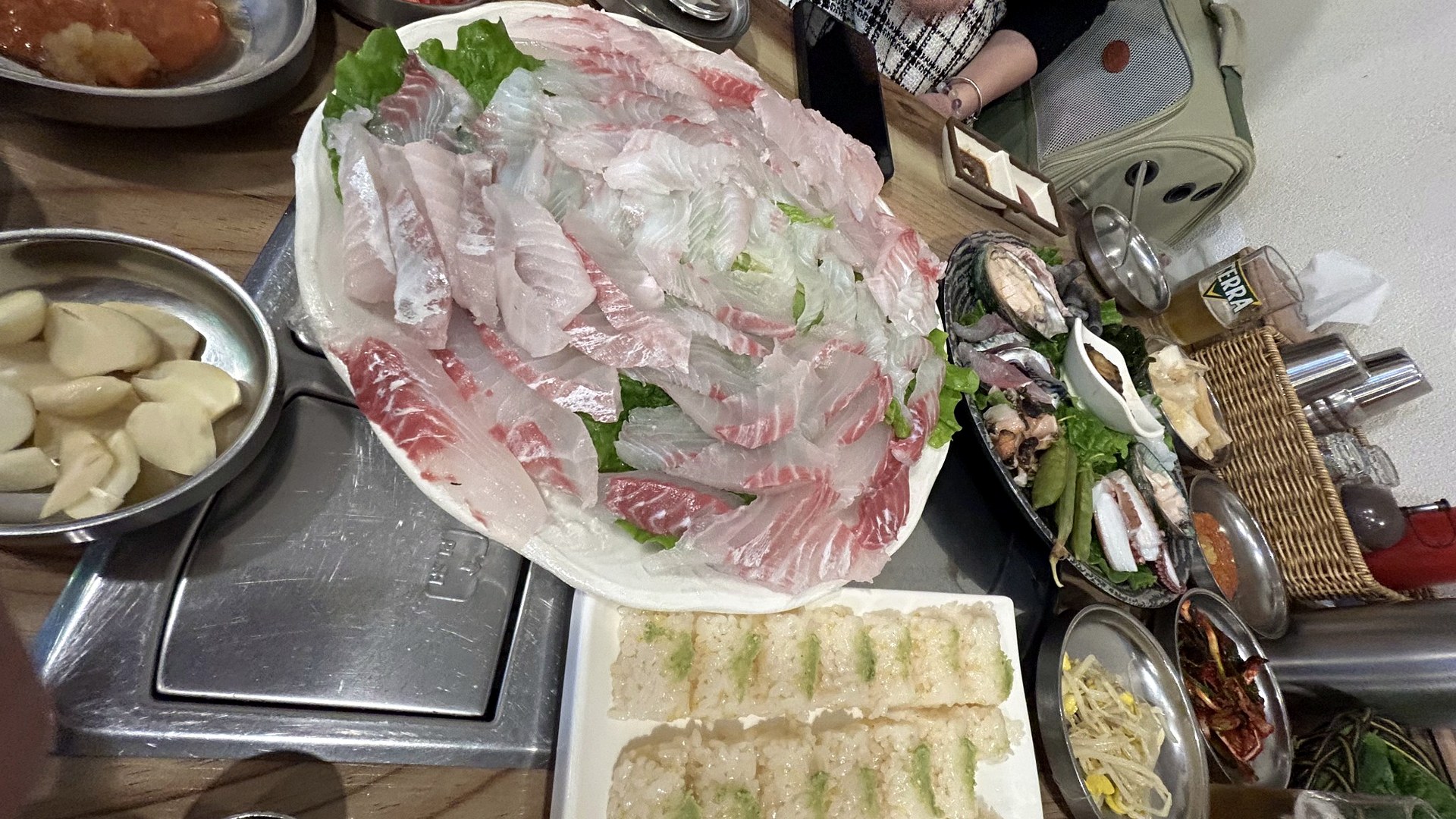 Dagumbari sashimi with side dishes on a Korean seafood restaurant table in Jeju