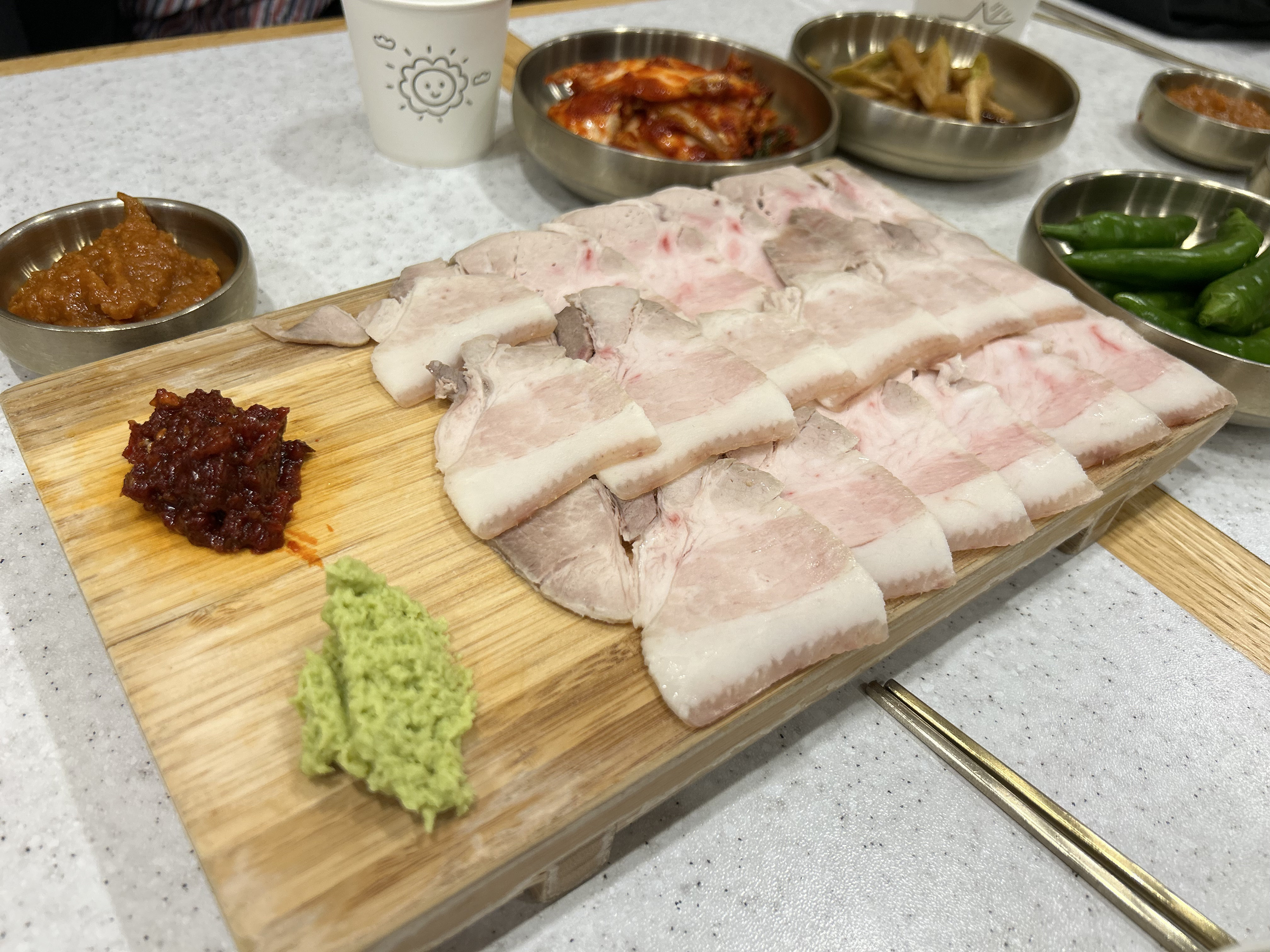 Dombe-gogi sliced boiled pork served on a wooden board in Jeju