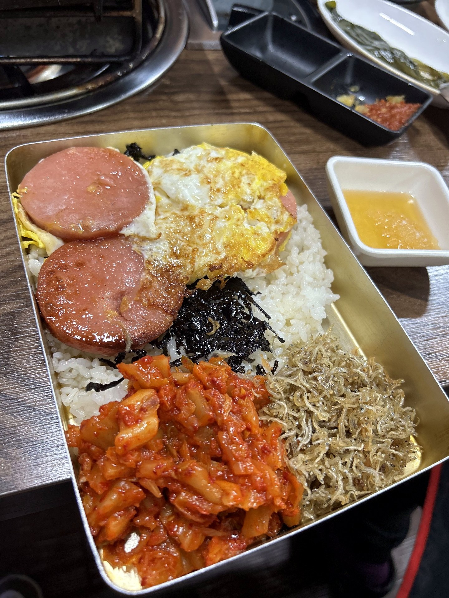 Korean nostalgic lunchbox with rice egg ham kimchi and anchovies