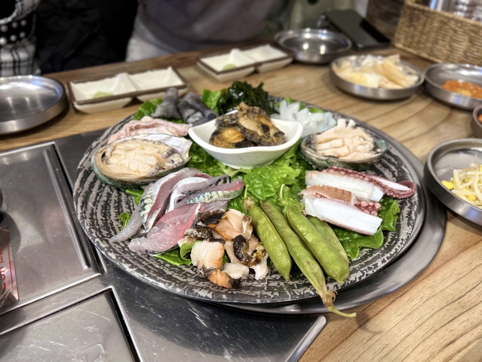 Seafood appetizer platter with abalone octopus and shellfish at a Jeju sashimi restaurant