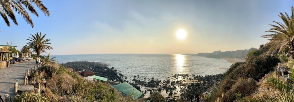 Panoramic coastal view in Jeju with volcanic rocks and sunset light