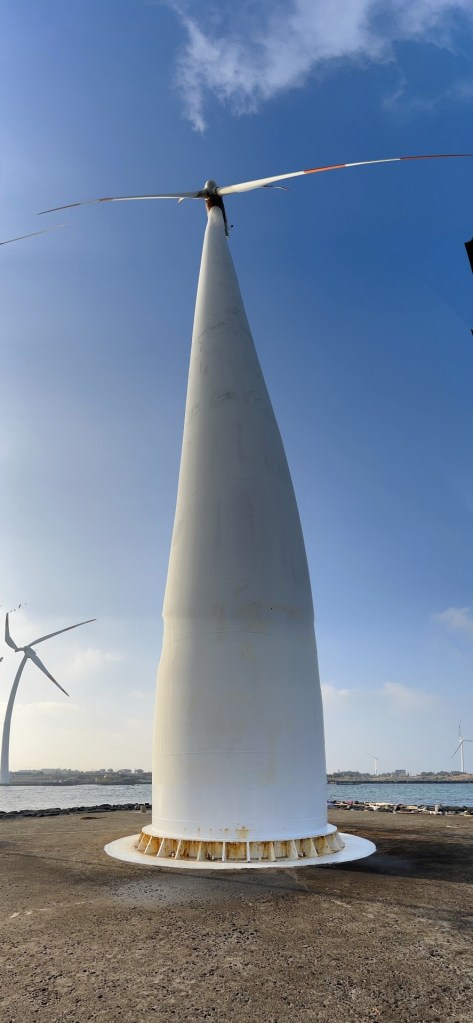 Wind turbine beside the sea at Sinchang Windmill Coastal Road in Jeju