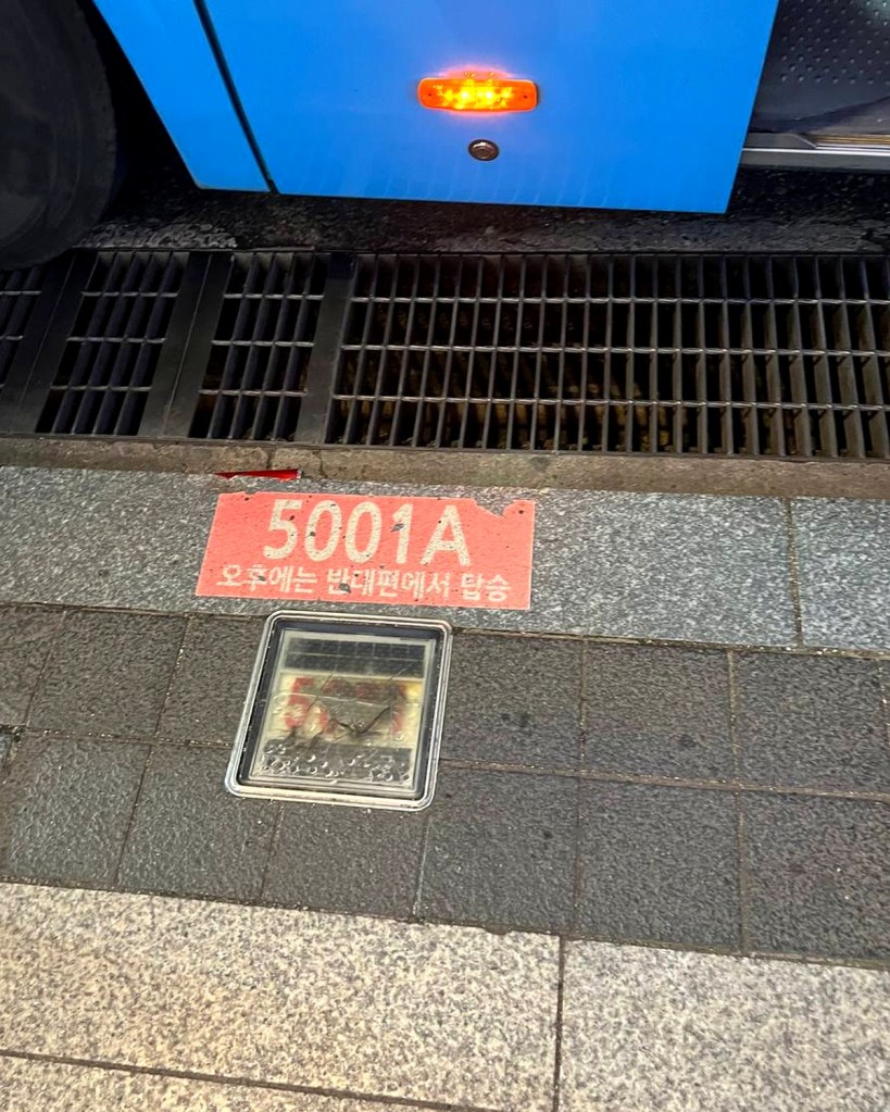 Bus route number 5001A marked on the ground at a Seoul bus stop